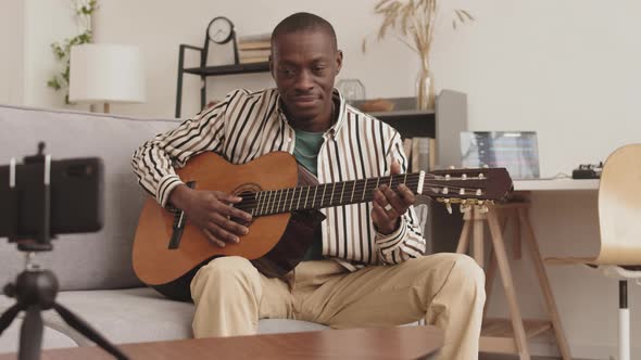 Male African Guitarist Recording Him Playing on Video