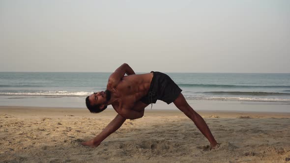 Young Flexible Man Doing Yoga Outdoors in Nature