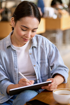 ing apps technology on digital tablet sitting at table remote working or elearning online, drawing or signing e document, studying with pad device.