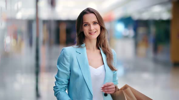Portrait of Happy Female Buyer Posing with Shopping Bag at Mall