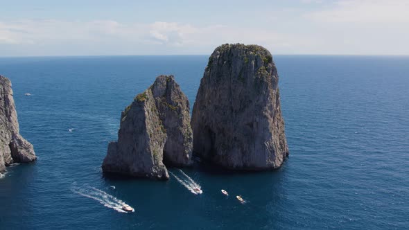 Pleasure boats explore dramatic rock formations (Faraglioni), Capri; aerial