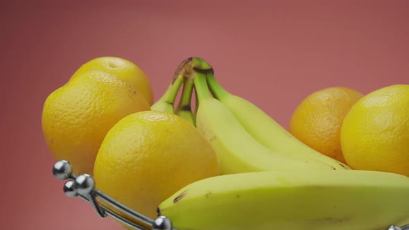 Bananas and Oranges on a Pink Background