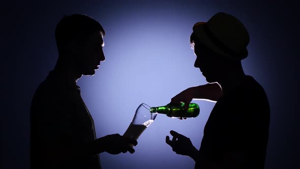 Two Male Friends Talking and Drinking Beer. Back Light