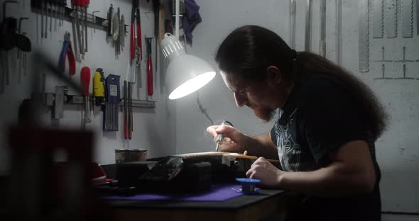 Luthier Heats Frets on Guitar By Soldering Iron Before Refretting Preparations for Frets Replacement