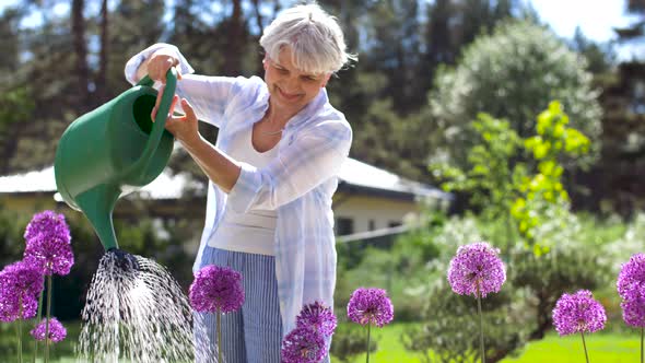 Senior Woman Watering Flowers at Summer Garden 18