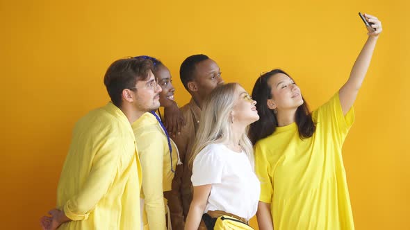 Interracial Group of Students Gathered Together To Take Selfie Islated in Studio with Yellow