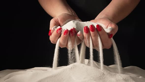 Woman Picks Up Clean White Sand in Her Palms and Sprinkles It Through Her Fingers