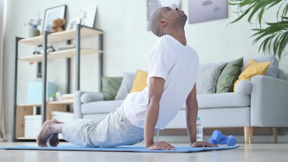 Young African Man Doing Yoga on Yoga Mat at Home