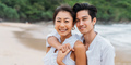 Happy smiling Asian 30s couple in relationship looking at camera on the beach in summer - PhotoDune Item for Sale