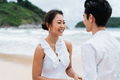 Happy toothy smiling Asian 30s couple in relationship in candid on the beach in summer - PhotoDune Item for Sale