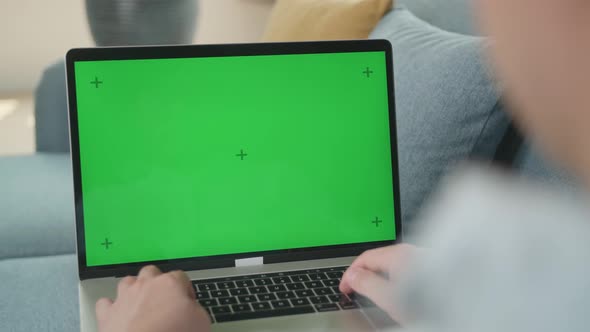 Male Working On Laptop With Green Screen Display