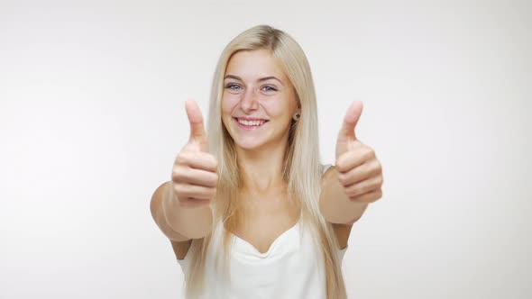 Caucasian Happy Young Woman with Long Blond Hair Having Fun Gesturing Thumbs Up Smiling Dancing