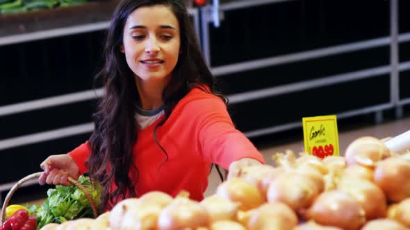 Woman selecting vegetable from organic section