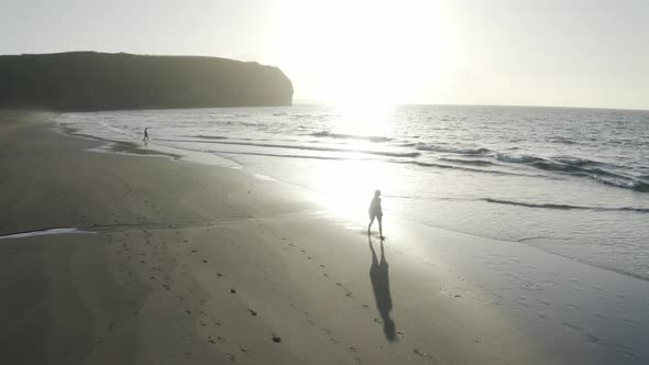 Aerial View of a woman walking on the beach, Praia do Areal, Azores, Portugal.