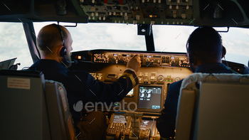 Airplane captain and copilot looking at radar compass on dashboard