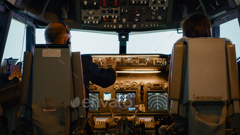 Captain and woman copilot in cockpit preparing to fly airplane