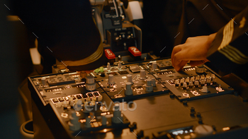 Captain and copilot pushing dashboard buttons to start engine