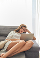 Woman relaxing on the sofa using laptop computer - PhotoDune Item for Sale