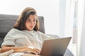 Woman relaxing on the sofa using laptop computer - PhotoDune Item for Sale