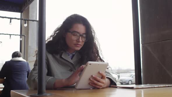 Young Woman Using Tablet in Outdoor Cafe