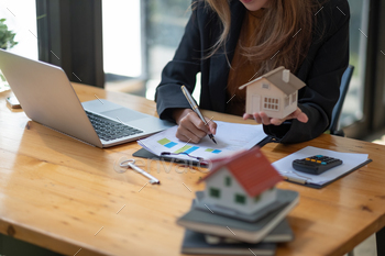 inesswoman doing finances and calculate about cost to real estate investment and tax.