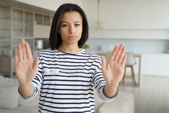 sign of prohibition or rejection, looking at camera at home. Serious strict female protesting against domestic violence, abuse, gender discrimination