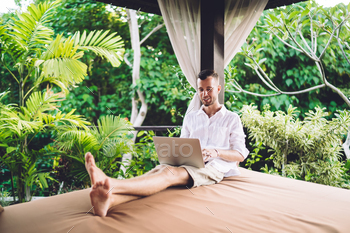 Skilled Caucaisan graphic designer working remotely via laptop technology - searching web pages