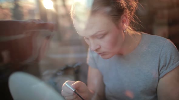 Portrait of a beautiful girl applying mascara to her eyelashes