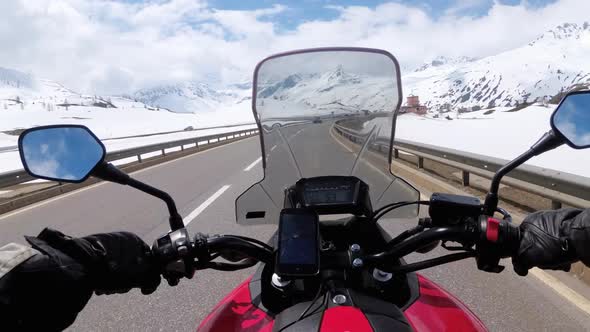 Motorcyclist Rides on Beautiful Landscape Snowy Mountain Road Near Switzerland Alps
