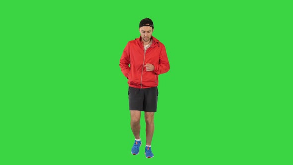 Young Man Running in a Windbreaker on a Green Screen Chroma Key