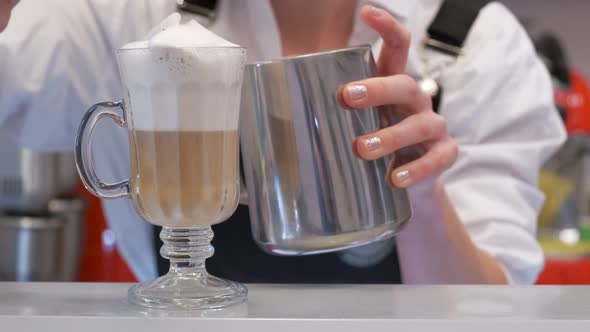 Barista Topping an Icecold Drink with a Frothy Milk Mixture