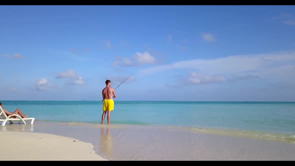 Romantic couple sunbathing on tropical bay beach adventure by aqua blue sea with white sandy backgro