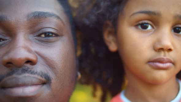 Head Shot Portrait of Smiling African Father and Little Daughter Outdoors