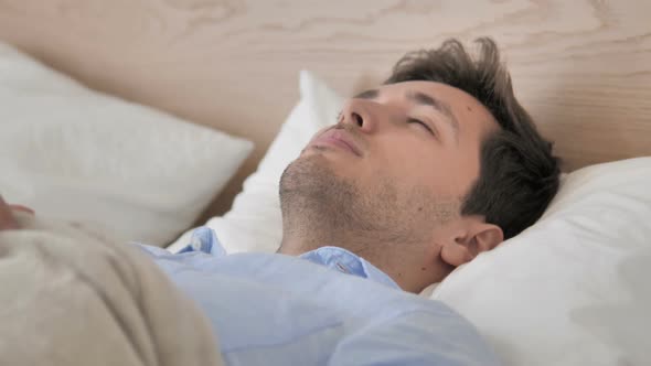 Pensive Young Man Thinking While Lying in Bed