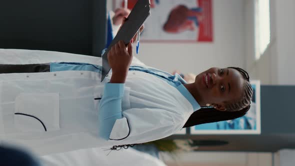 Vertical Video Portrait of African American Medic with Uniform and Checkup Report
