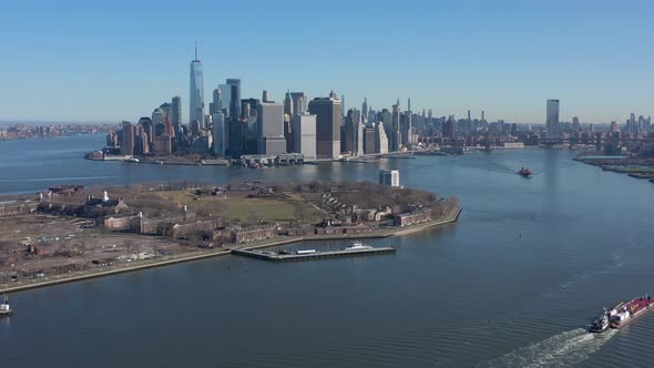 An aerial view of New York harbor on a sunny day with clear blue skies. The drone camera dolly in ov