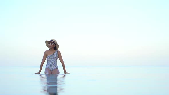 Young asian woman enjoy around outdoor swimming pool for leisure