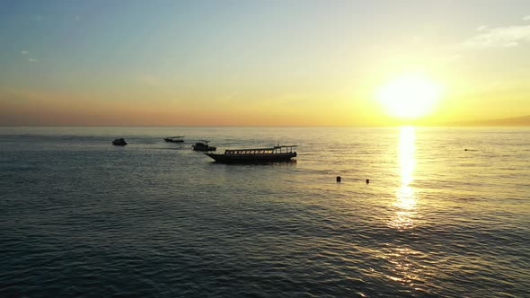 Idyllic tropical landscape with sunset sky, open ocean and fisherman boats