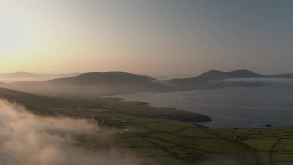 Early morning clouds drift over the mountains in Co Kerry Ireland as the sun shines during the summe