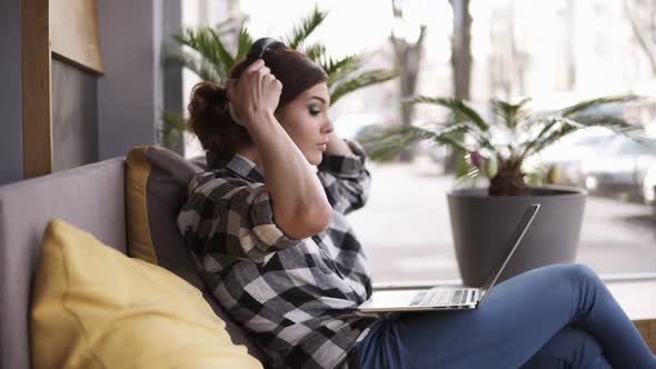 A Girl with Long Hair is Sitting on the Couch