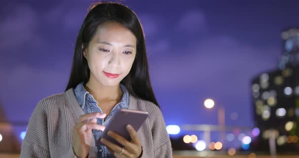 Woman use of smart phone at outdoor in winter time at night