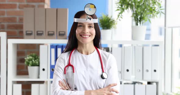 Doctor Otolaryngologist in White Coat and Mirror on Head Closeup