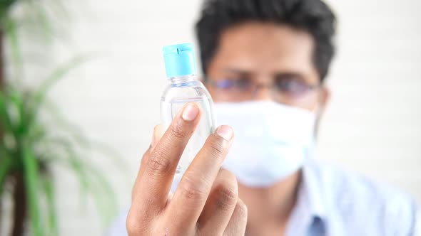 Man in Mace Mask Holding Surgical Face Mask