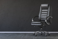 Black office chair in black interior with space for text. - PhotoDune Item for Sale