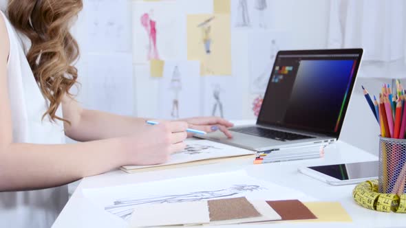 Artist Looks at the Computer and Selects Shades for a New Collection of Clothes