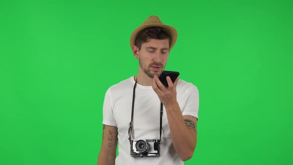 Portrait of Confident Guy Is Asking for Information on the Network Via Phone. Green Screen