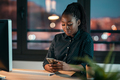 Beautiful business woman sending messages with mobile phone while working in the office. - PhotoDune Item for Sale