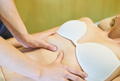 Woman receiving a massage from a professional osteopath on the abdomen - PhotoDune Item for Sale