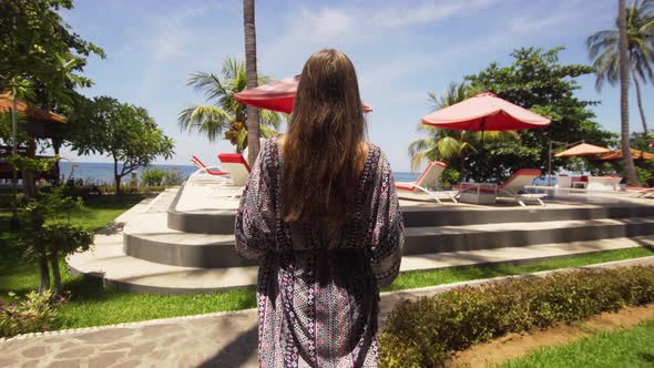 Girl with a Glass of Cocktail Near To the Pool