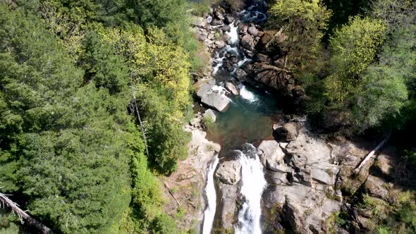 Drone footage panning down stream to the water fall at Coquille falls. Pristine clean water flowing